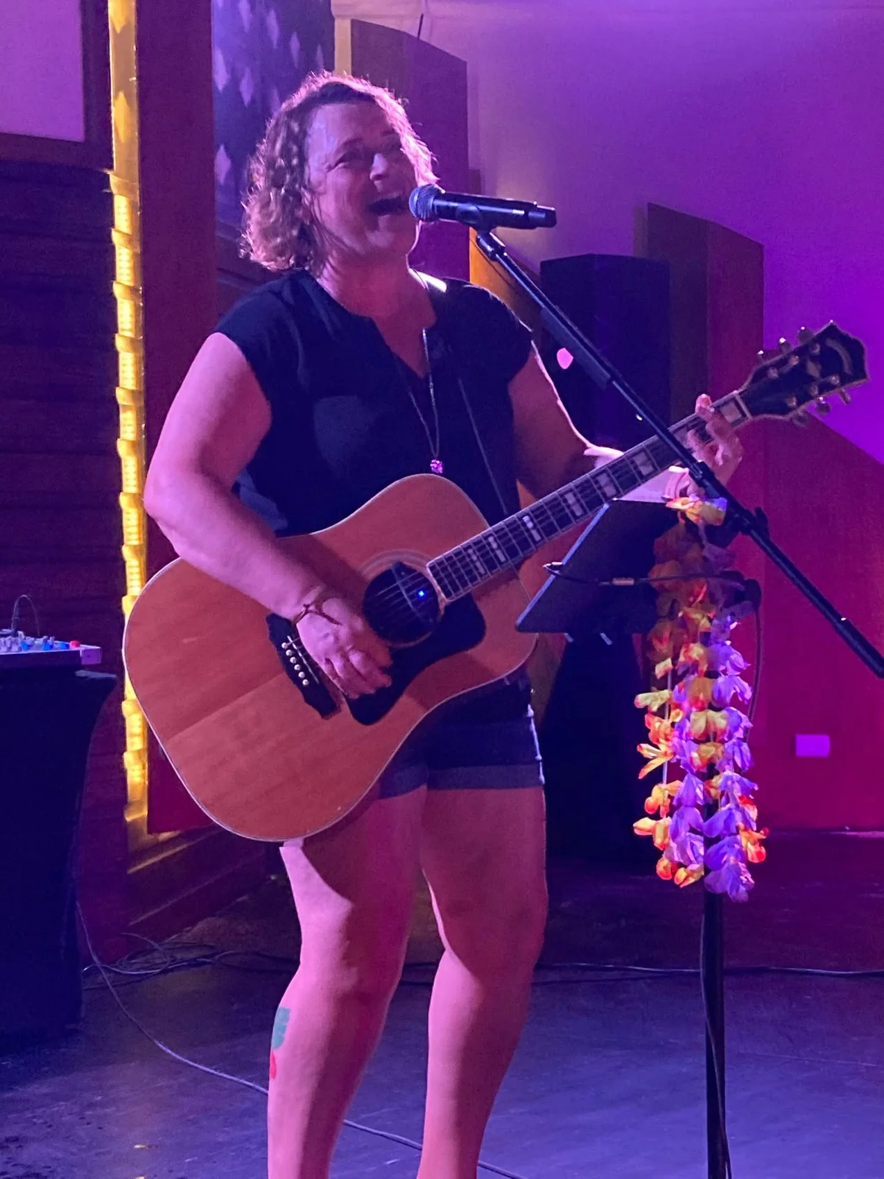 Lisa singing and playing guitar during a live performance